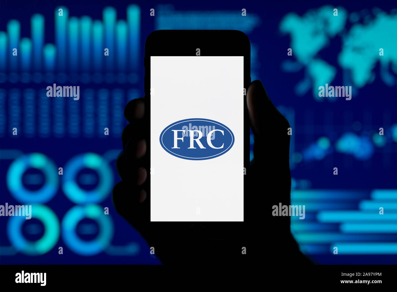 Ein Mann hält ein iPhone, das zeigt die Finanzielle Berichterstattung logo, Schuß gegen eine Visualisierung von Daten im Hintergrund (nur redaktionelle Nutzung). Stockfoto