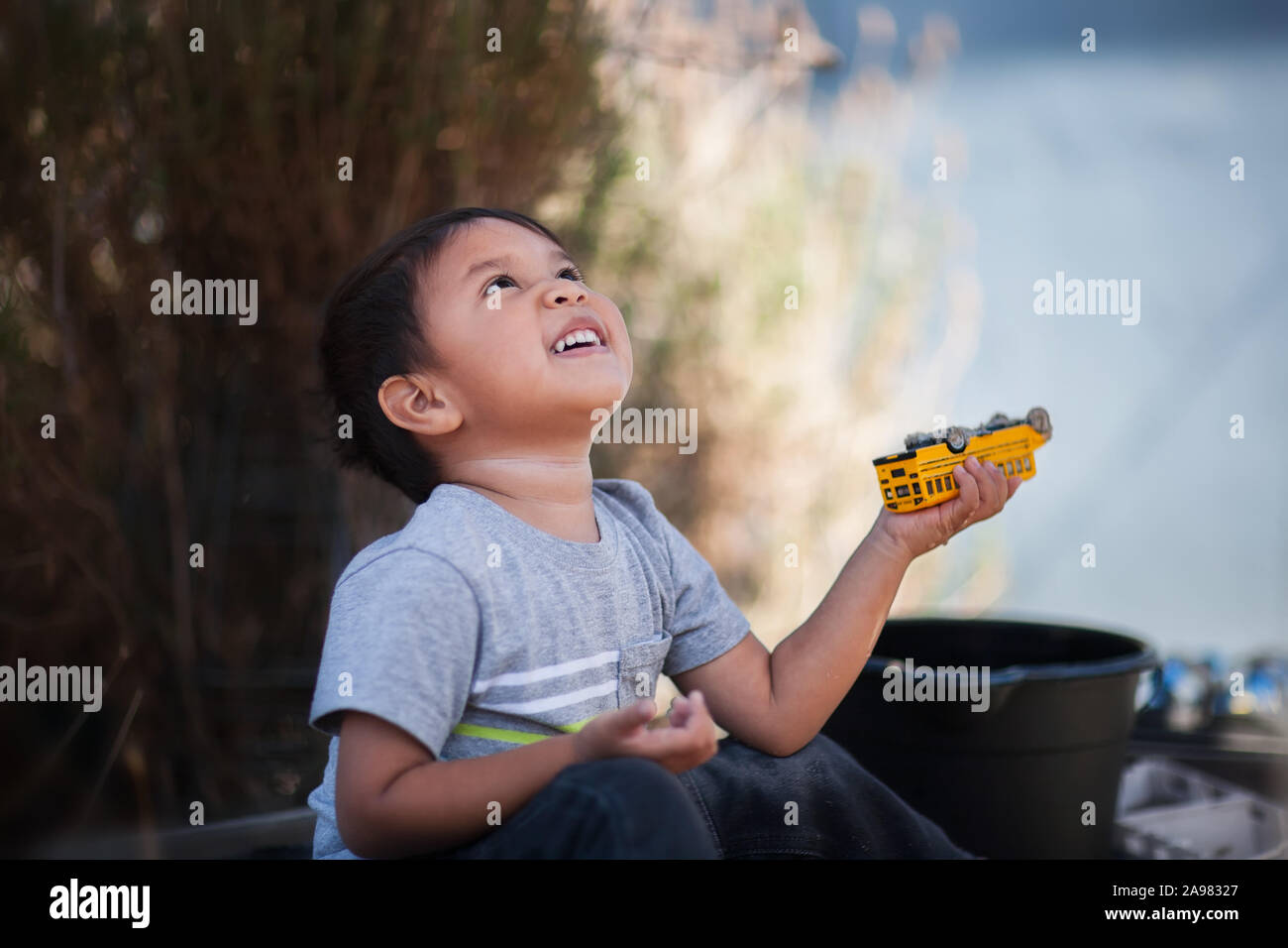 Ein Junge mit Spielzeug spielen, blickte in den Himmel und dankbar. Stockfoto