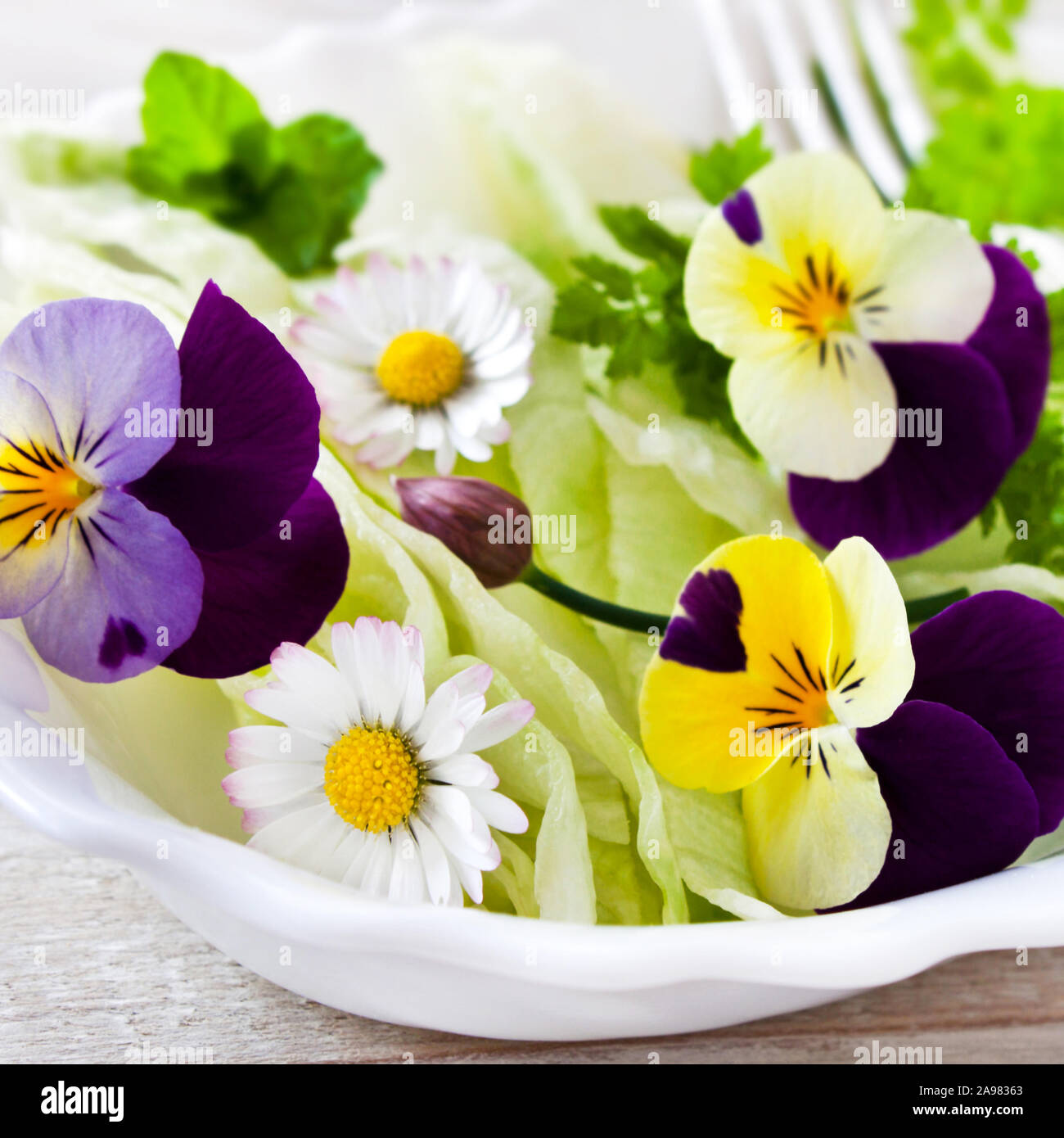 Frischer Salat mit verschiedenen essbaren Blumen Stockfoto