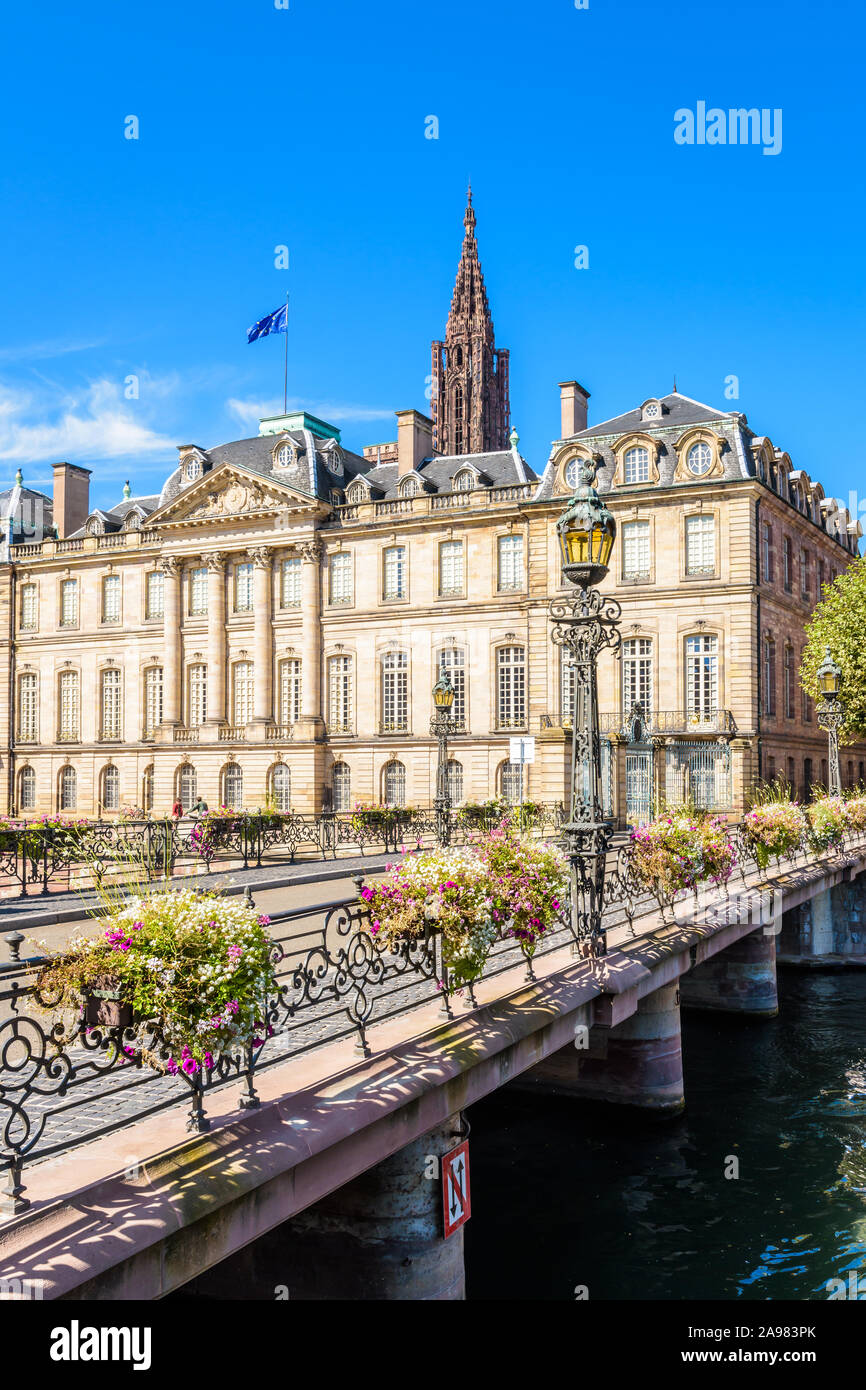 Fassade des Palais Rohan in Straßburg, Frankreich, mit Blick auf die Ill mit dem Turm der Kathedrale Notre-Dame über das Dach ragt. Stockfoto