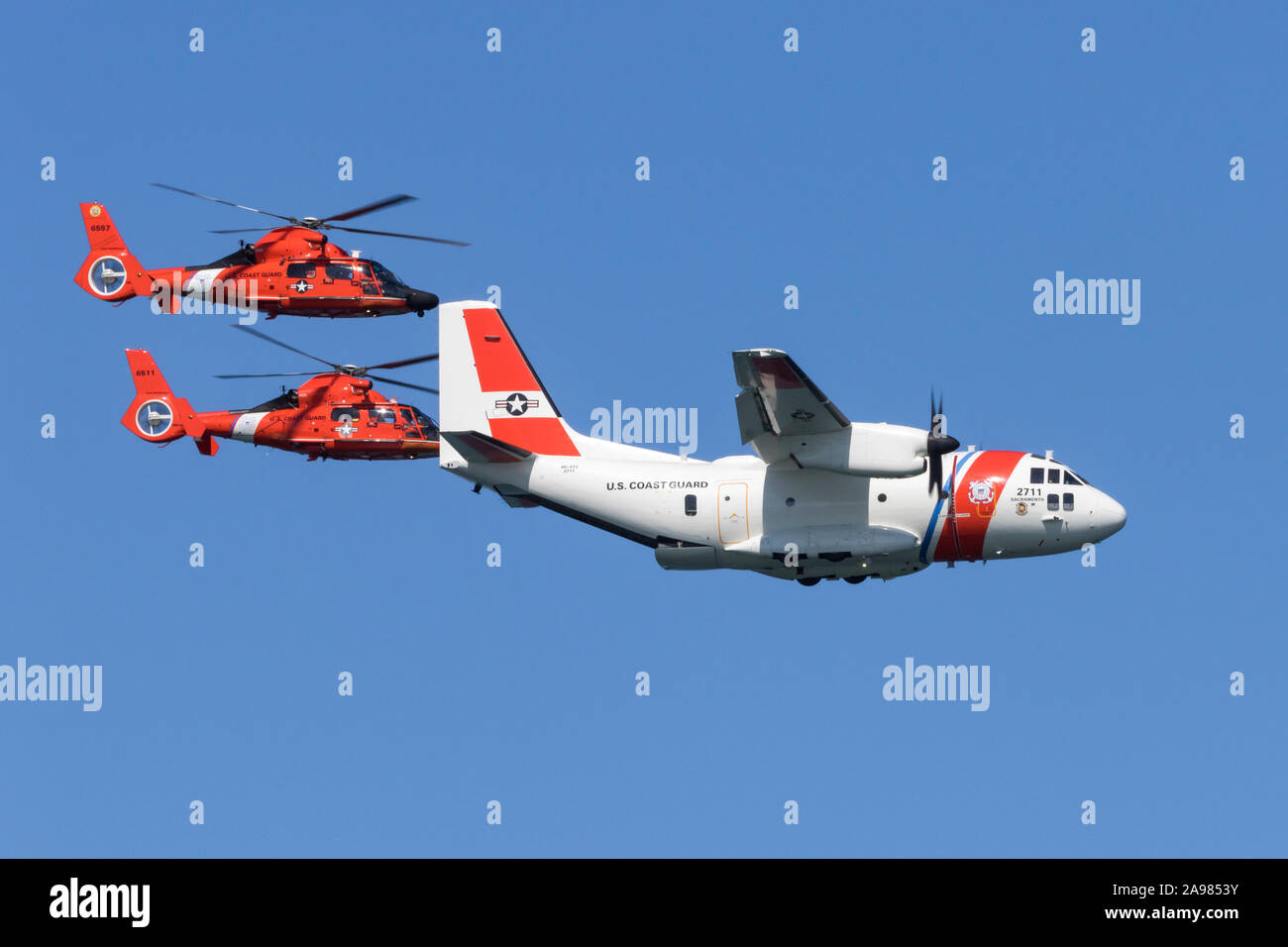 Ein paar der Küstenwache MH-65 Dolphin Helikopter der Air Station San Francisco fliegen in enger Formation mit einem C-27 J Spartan von Air Station Sacramento Stockfoto