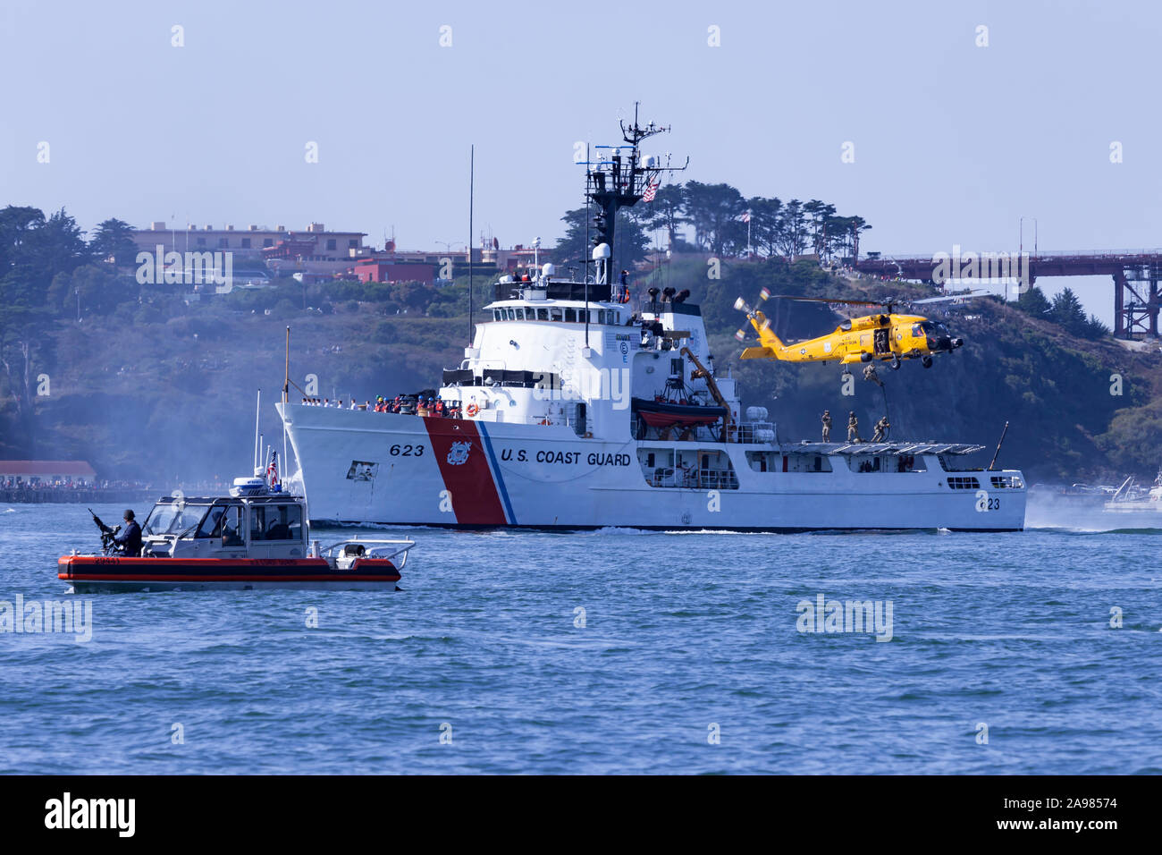 Der Küstenwache MSST steht Sentry als United States Coast Guard MH-60 Jayhawk schwebt über dem Patrouillenboot standhaft (WMEC-623) mit Kräften rep Stockfoto
