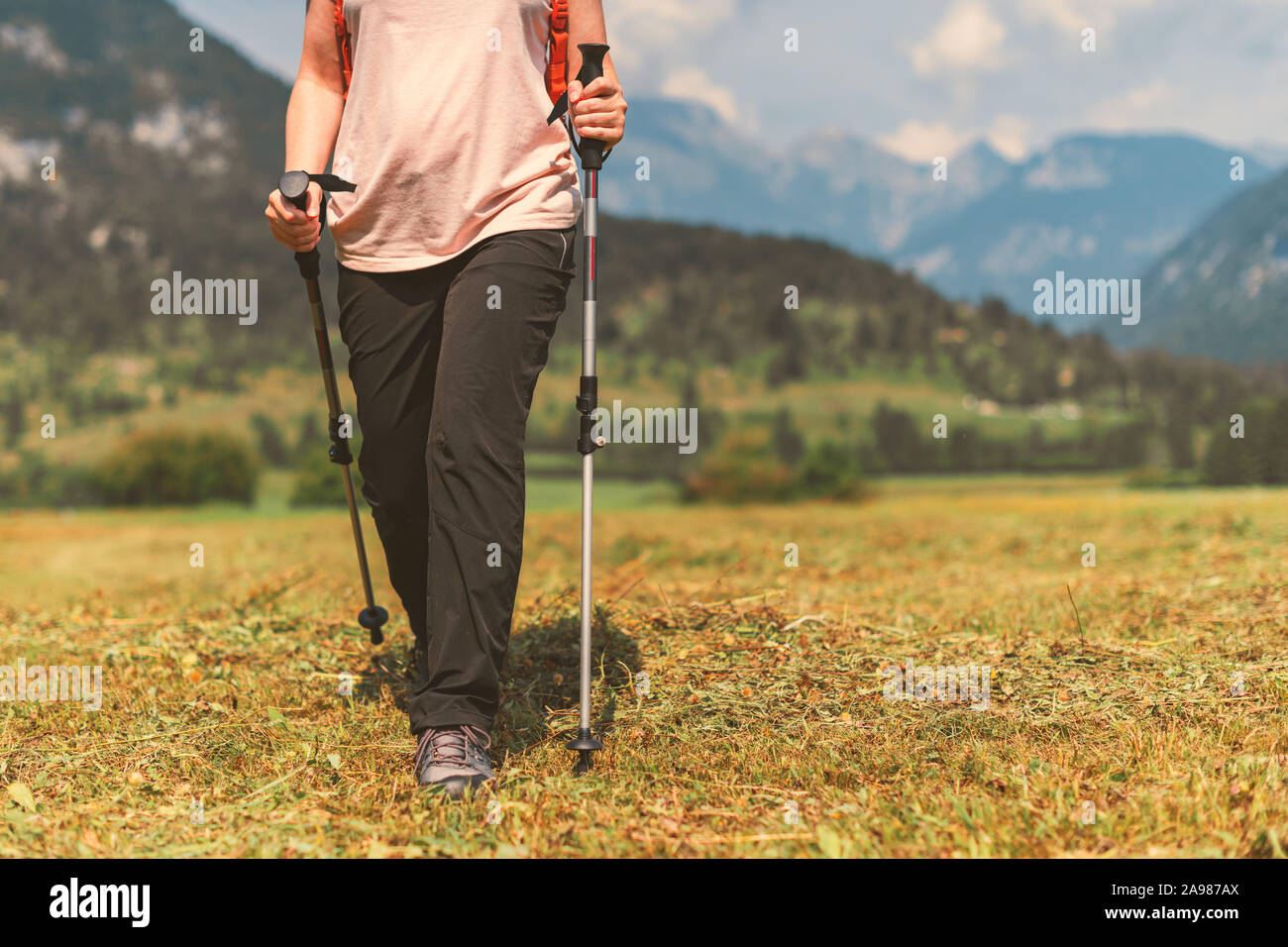 Weibliche Wanderer ist Trekking in alpine Landschaft Landschaft im sonnigen Herbst 12:00 Uhr Verwendung von Wanderstöcken, selektiver Fokus Stockfoto