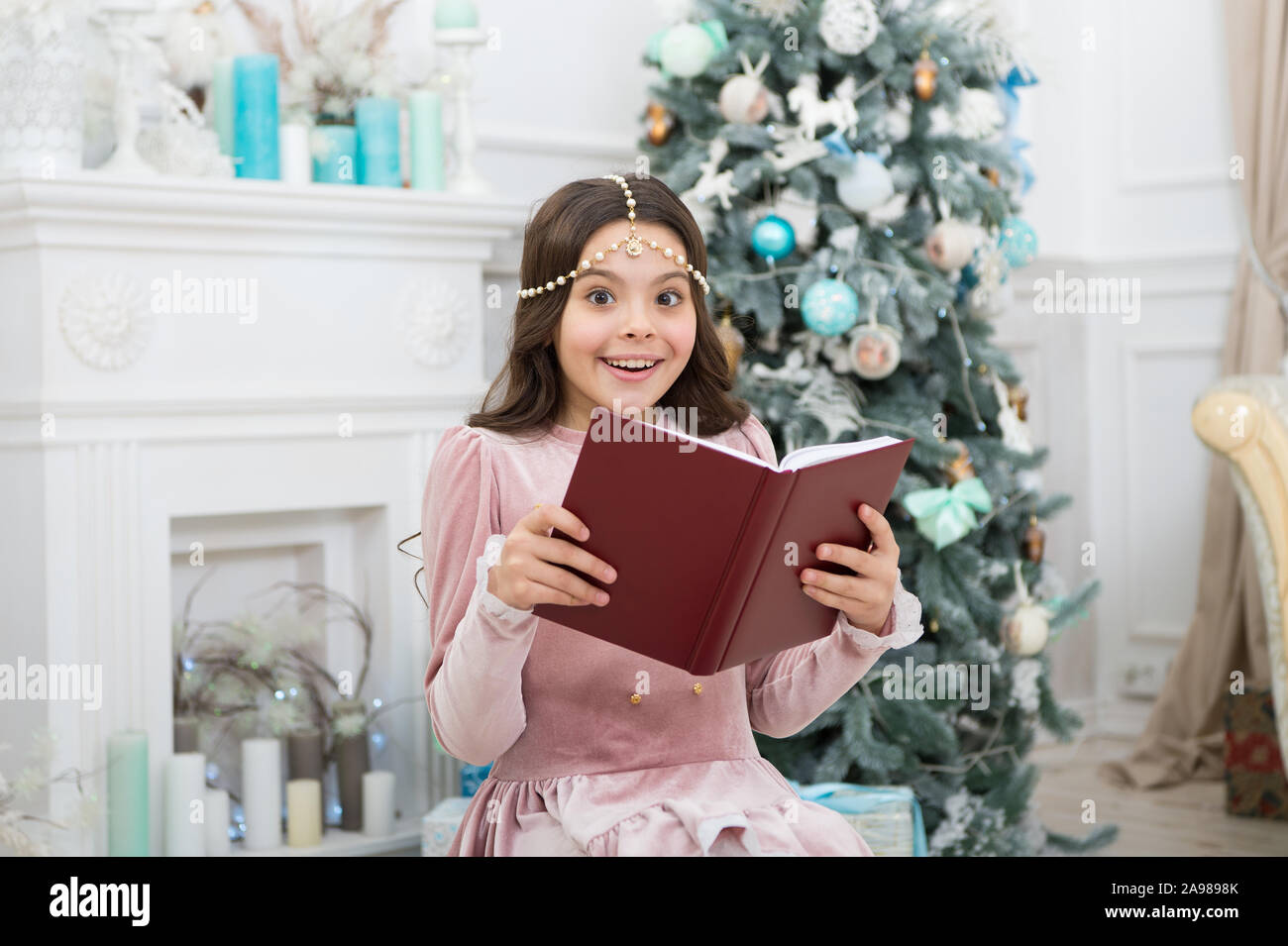 Was wissen Sie Phantasie für das Neue Jahr. Glücklich halten fantasy Buch an den Xmas Tree. Weihnachten Kind lesen fantasy Geschichte. Kinder Phantasie und Vorstellungskraft. Märchen. Stockfoto