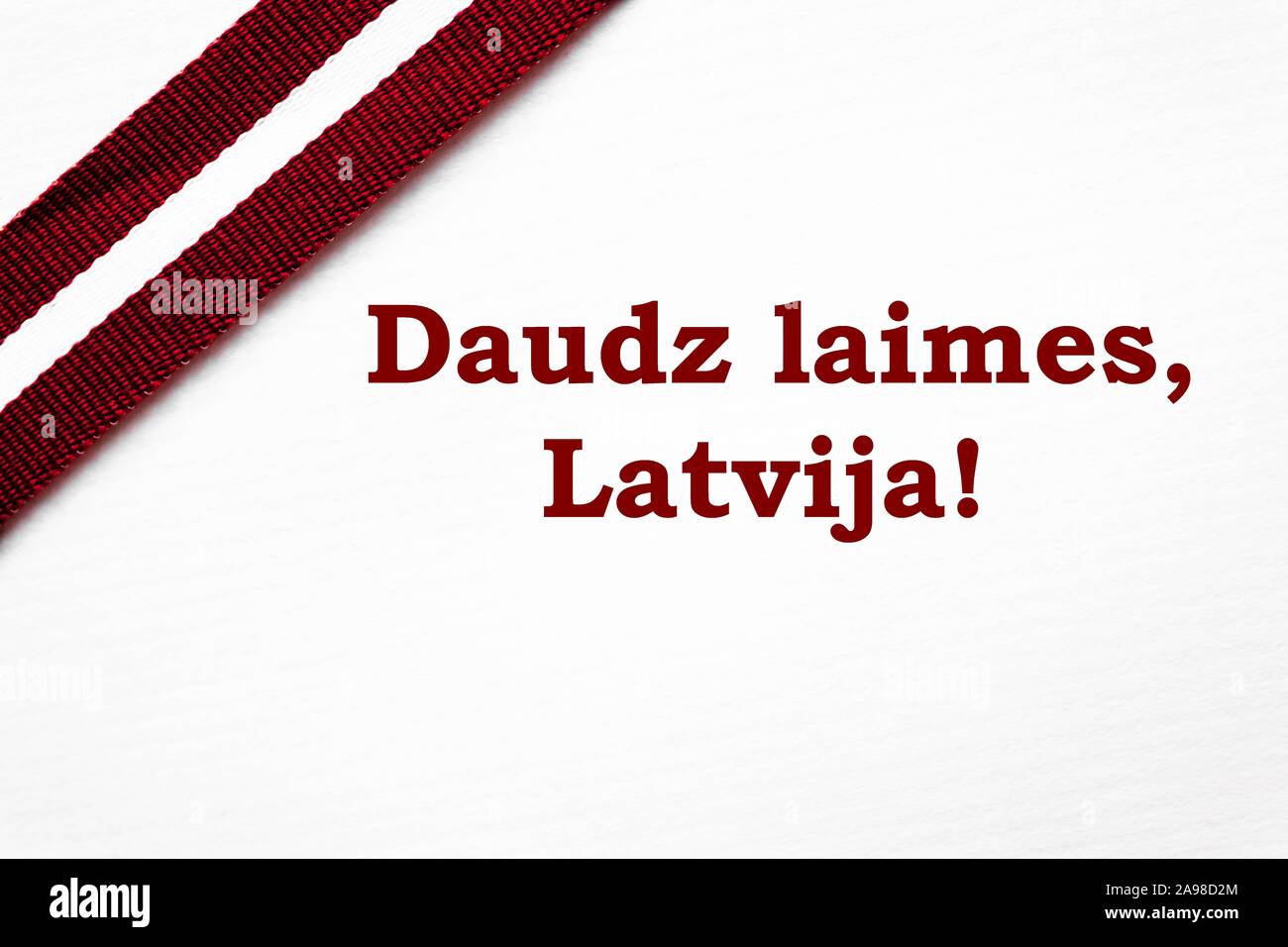 Farbband in die lettische Flagge Farben auf weißem Hintergrund mit Glückwunschschreiben' großes Glück, Lettland!". Stockfoto