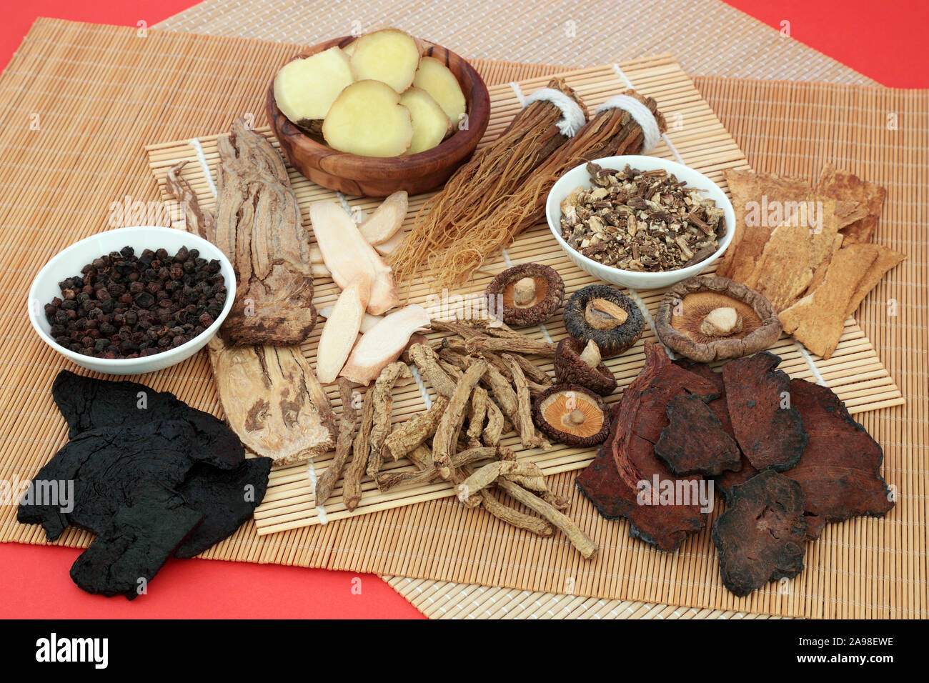Chinesische Kruter verwendet als Strkungsmittel in traditionelle  pflanzliche Medizin auf Bambus und roten Hintergrund Stockfotografie - Alamy