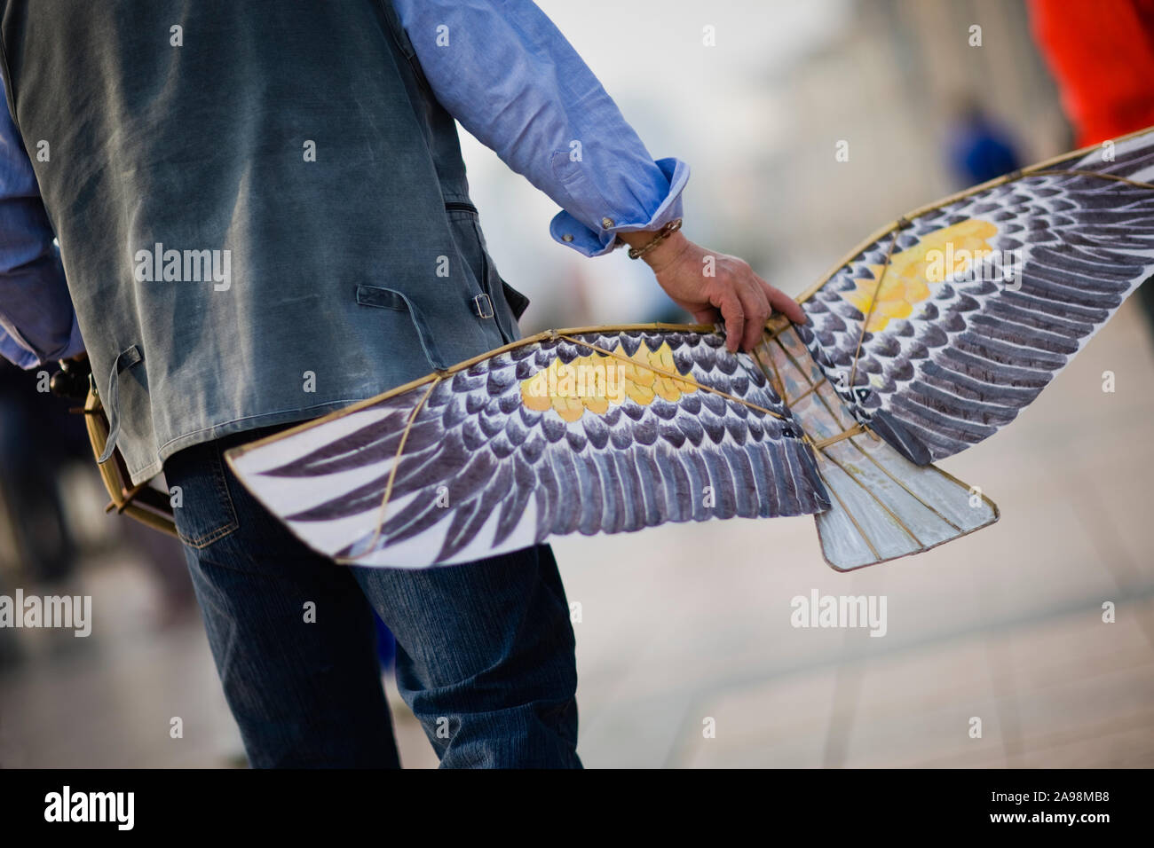 Mann, der einen Drachen in der Form eines Adlers. Stockfoto