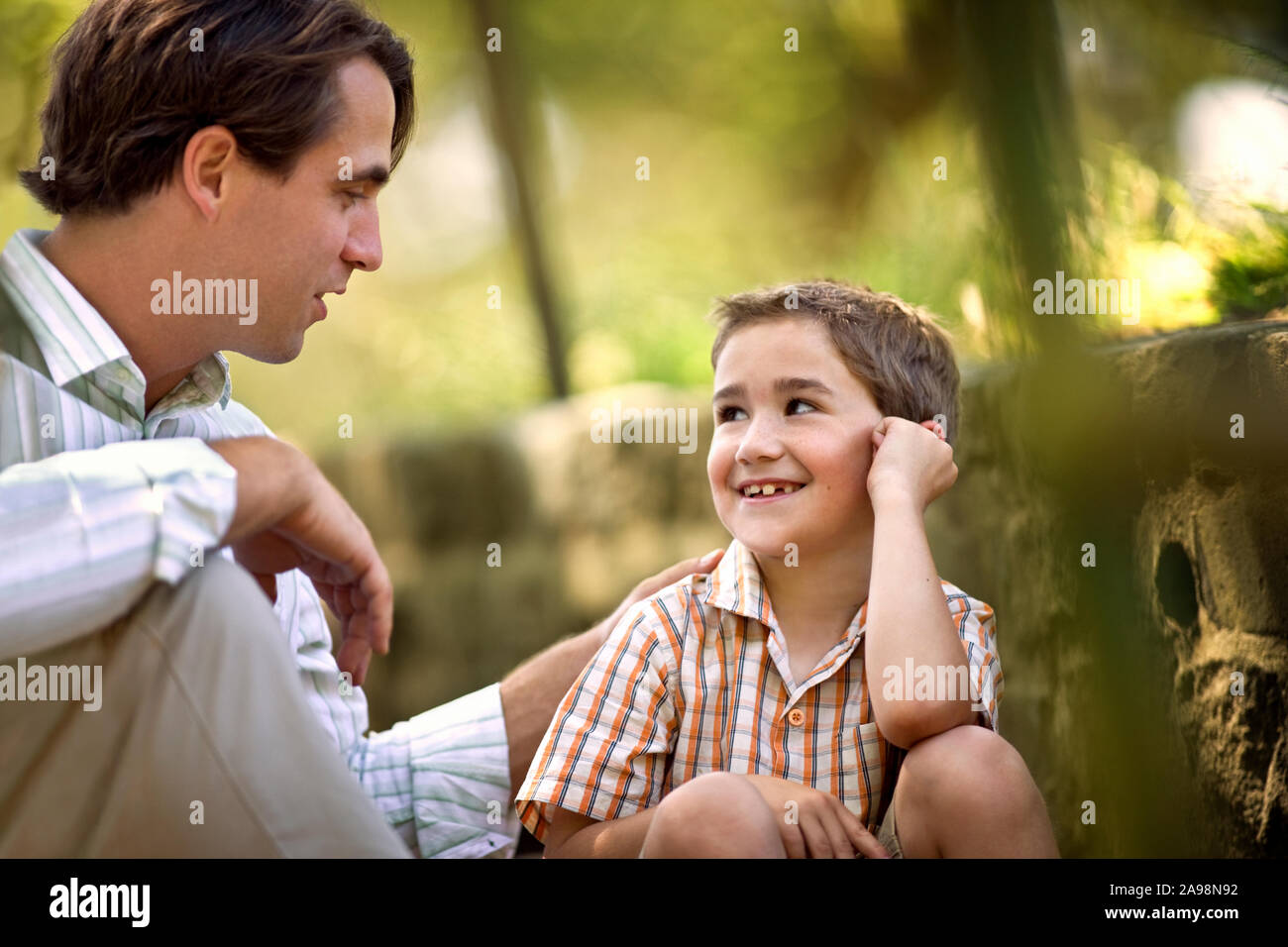 Mitte der erwachsenen Mann im Gespräch mit seinem jungen Sohn. Stockfoto