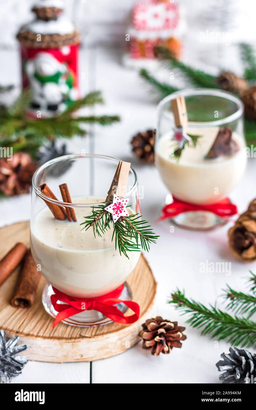 Ein traditionelles Eierlikör Weihnachten Drink in ein Glas Becher dekoriert mit neuen Jahr Wäscheklammer. Nicht-alkoholische Option. Stimmungsvolle Fotos. Stockfoto