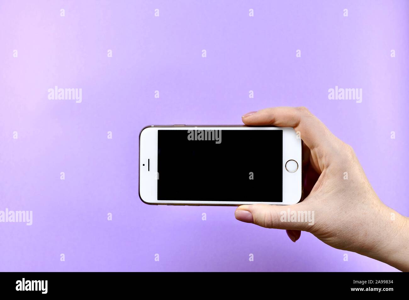 Ein Smartphone mit einem schwarzen Bildschirm, nur in der Bürste, horizontal in der Mitte, an der Unterseite. Stockfoto