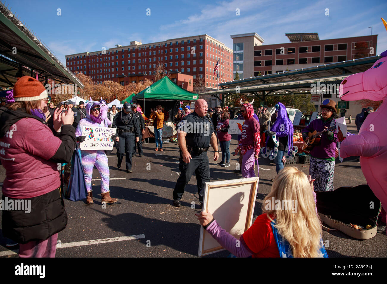 Polizisten geben Sie die Bloomington Gemeinschaft Farmers Market Demonstranten zu Fragen protestieren gegen Schooner Creek Farm Gesicht verhaften zu lassen, oder am Samstag, den 9. November 2019 in Bloomington, Ind die Gebühren wurden ordnungswidriges Verhalten, und Hausfriedensbruch vorgeworfen. Stockfoto