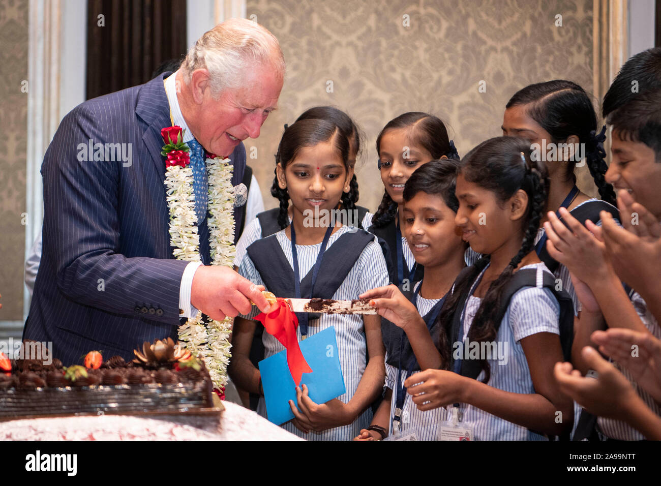 Der Prinz von Wales bietet ein Stück Kuchen zu einer Schule Mädchen während einer Britisch-asiatische Vertrauen Empfang in Mumbai, an Tag zwei des königlichen Besuch in Indien. Stockfoto