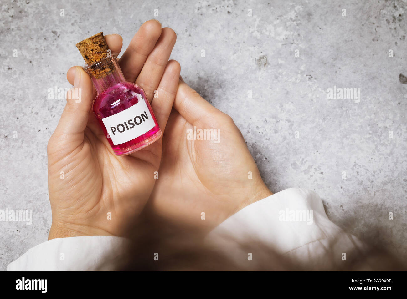 Flasche mit Gift in den Händen eines Arztes. Illegale Herstellung von giftigen Substanzen. Stockfoto