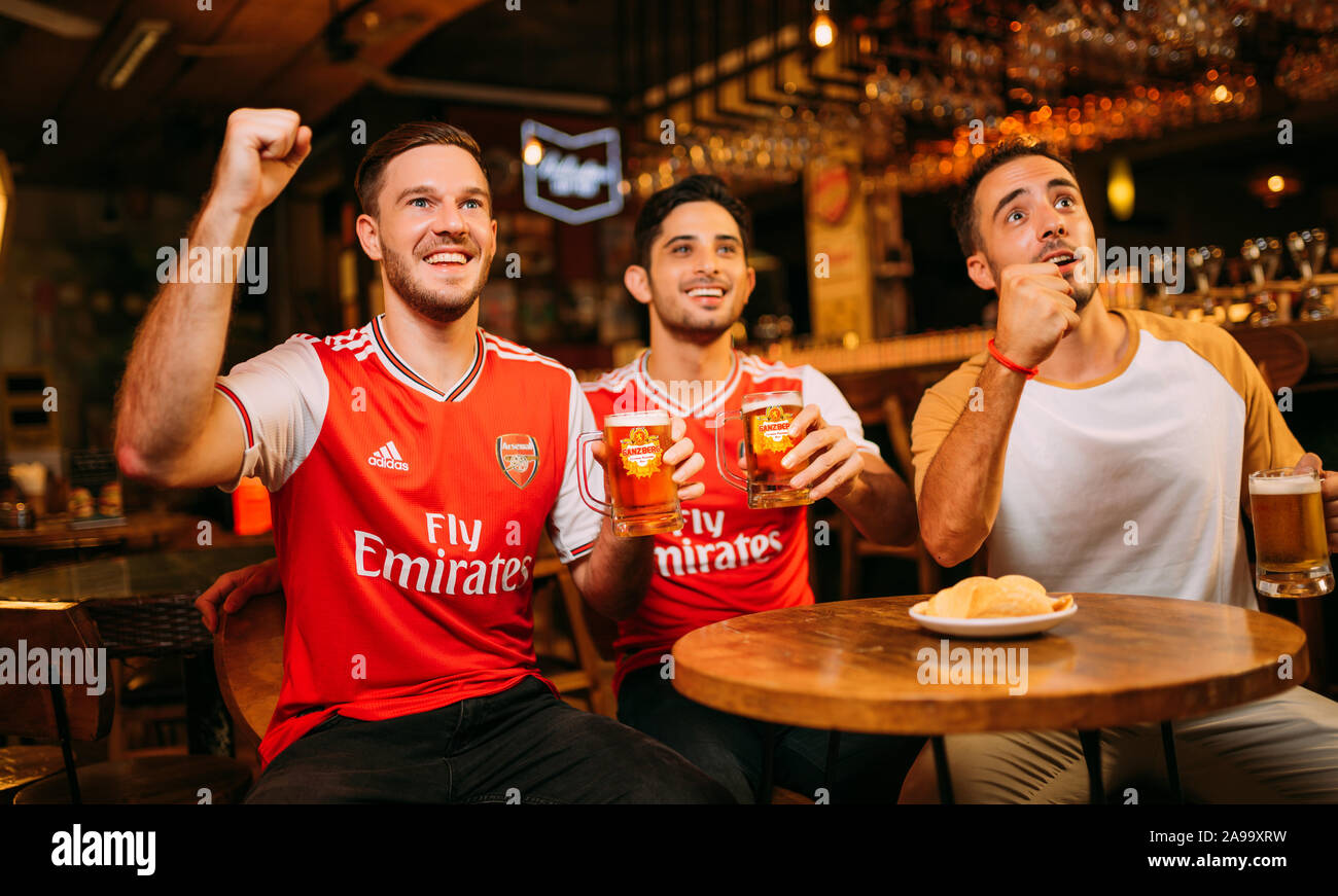 Party aufgeregt Arsenal Fans beobachten Fußball mit Ganzberg Bier in Das Pub Stockfoto