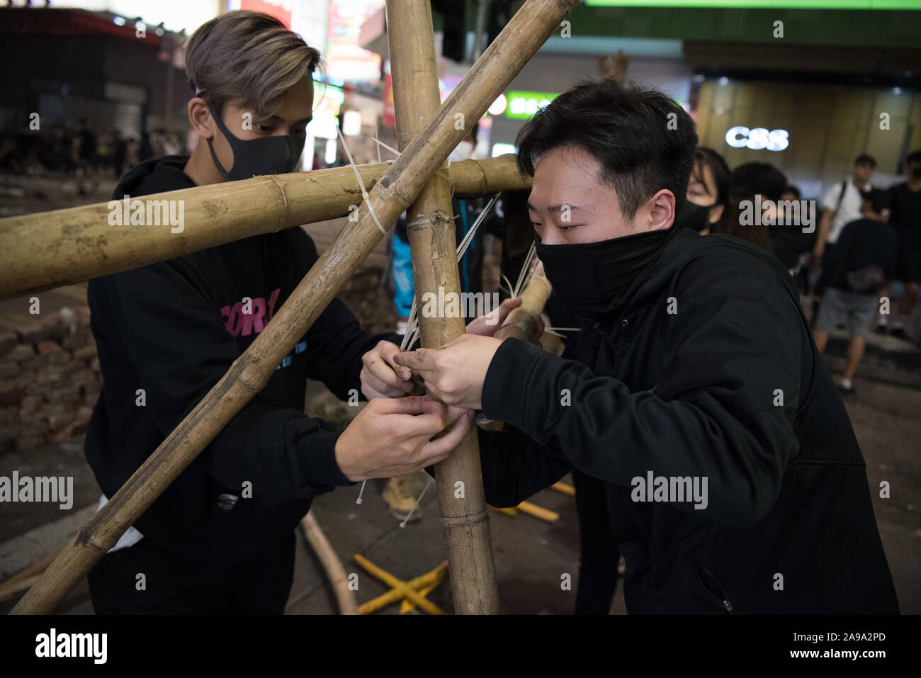 Die Demonstranten Barrikaden Bauen mit Bambus in Mong Kok. Die Protestbewegung hat eine Spitze in der Gewalt seit dem Tod von Student Alex Chow am 9. November gesehen, nach einem Sturz aus dem Sims auf einem Parkplatz während angeblich Flucht Gas durch die Polizei feuerte Tränengas. Trotz der umstrittenen Auslieferung Rechnung, die ursprünglich funkte die Proteste formell zurückgezogen, Demonstranten weiter auf Chief Executive Carrie Lam zu nennen Ihre restlichen Forderungen, die umfasst das allgemeine Wahlrecht, eine unabhängige Untersuchung über die Brutalität der Polizei, Rückzug des Wortes 'Ausschreitungen' t beschreiben zu erfüllen Stockfoto