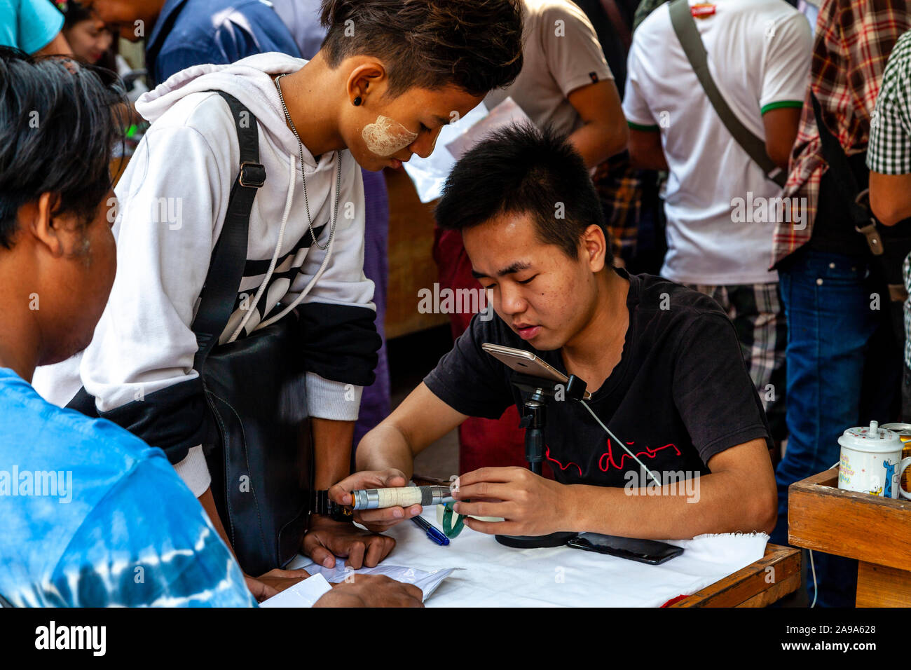 Ein Händler Prüfung Jade Steine an der Jade Market, Mandalay, Myanmar. Stockfoto