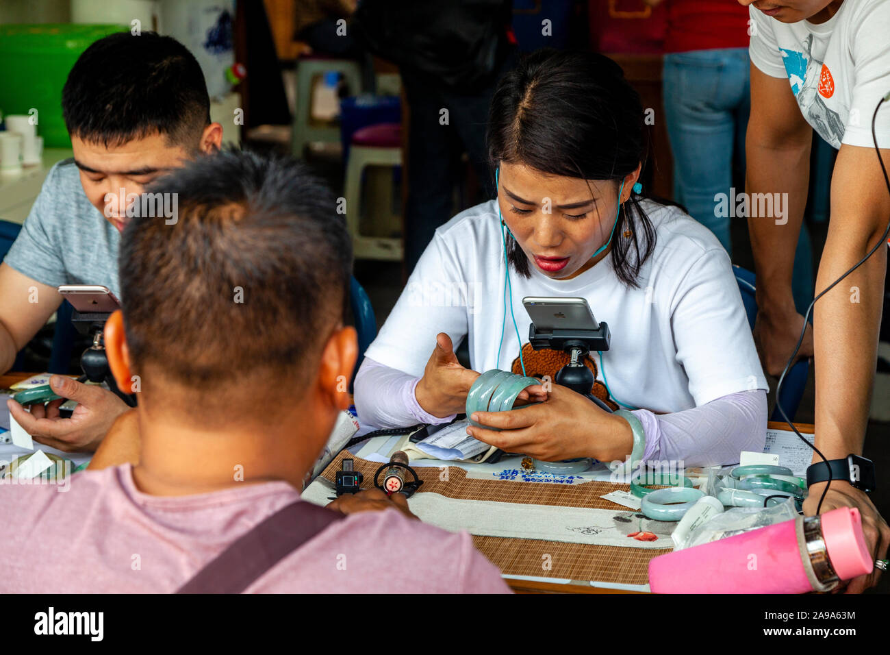 Eine weibliche Händler Prüfung Jade an der Jade Market, Mandalay, Myanmar. Stockfoto