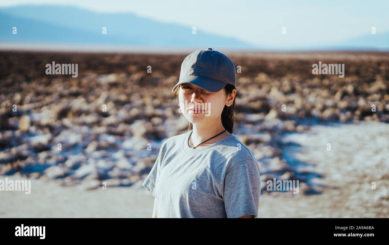 Asiatische Mädchen mit einer Kappe in Richtung der Kamera in das badwater Basin im Death Valley, Kalifornien, USA Stockfoto