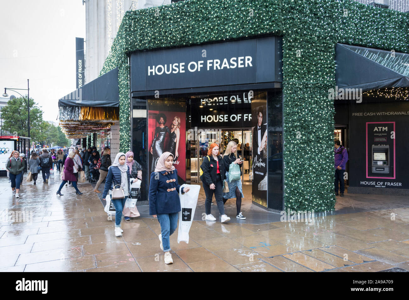 Pre-Christmas Käufer außerhalb des House of Fraser Haupteingang auf der Oxford Street, London, UK Stockfoto