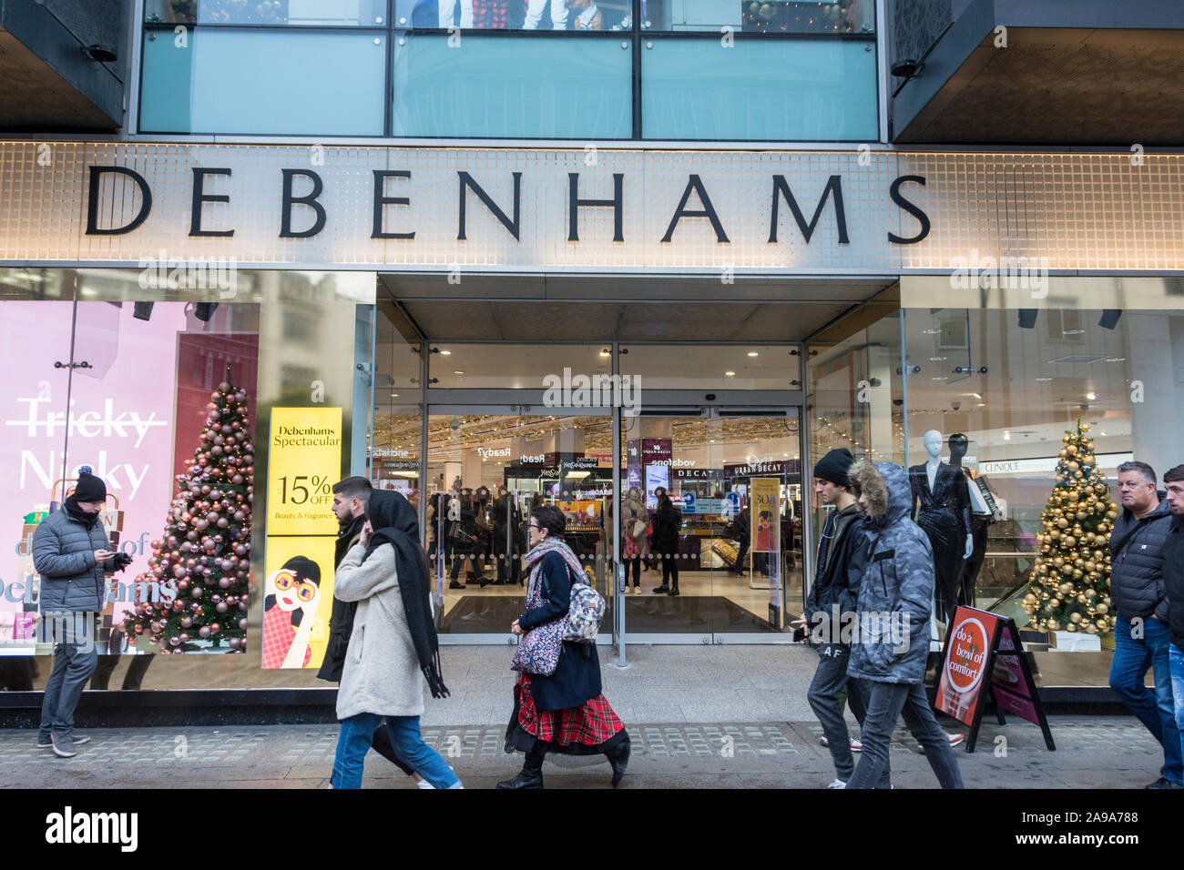 Pre-Christmas Käufer außerhalb Debenhams Haupteingang auf der Oxford Street, London, UK Stockfoto