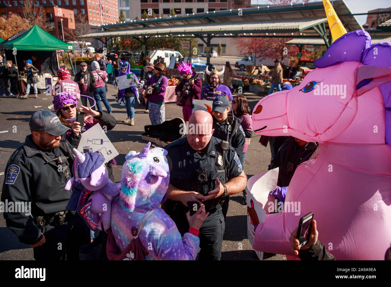 Bloomington, USA. 09 Nov, 2019. Polizisten Demonstranten fordern die Bloomington Gemeinschaft Farmers Market während der Demonstration zu verlassen. Polizei Aktivisten als Riese Einhorn, Wonder Woman und Wikinger, nachdem sie bei einem Bauernmarkt in Indiana demonstrierten gegen "weißer Überlegenheit gekleidet festgenommen.' Das lila Hemd Brigade ist ein Aktivist der Koalition in diesem Jahr in Bloomington gebildet, Lila trägt ihre öffentlich gegen weiße Vorherrschaft zu vertreten. Credit: SOPA Images Limited/Alamy leben Nachrichten Stockfoto