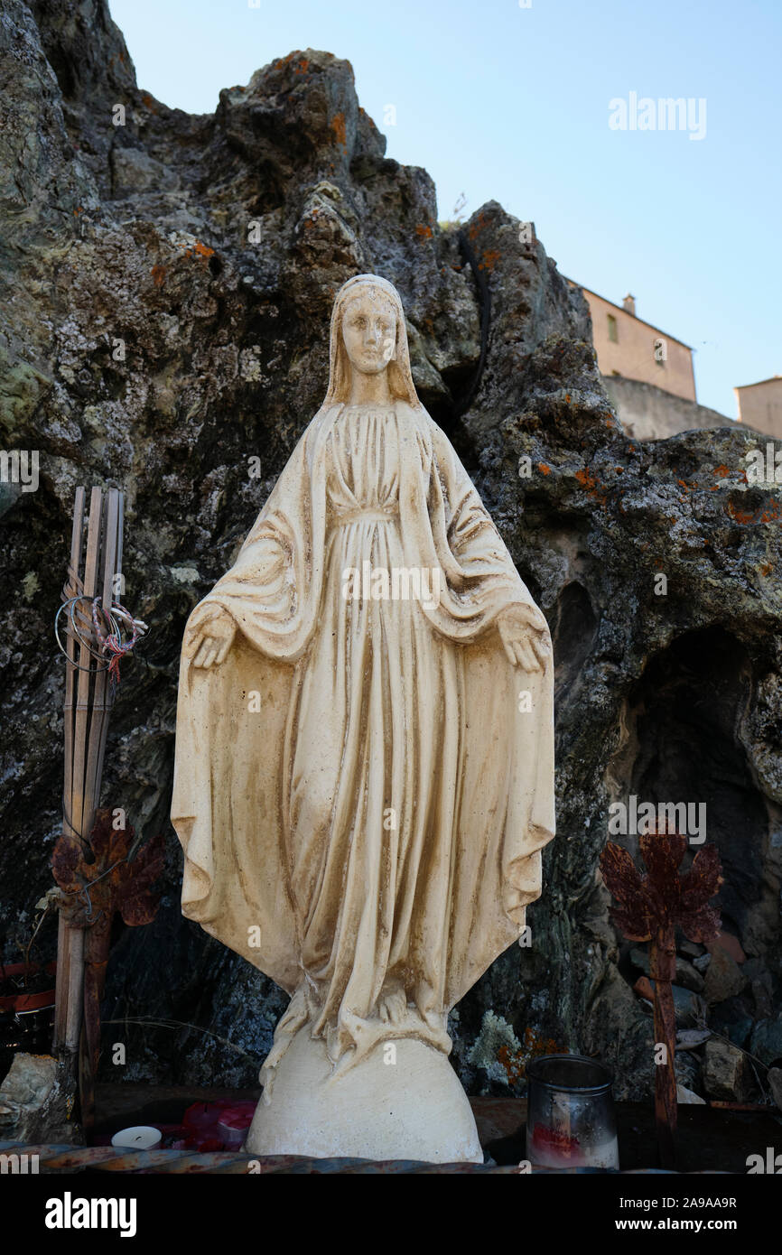 Eine steinerne Statue Jungfrau Maria Abbildung mit offenen Armen in Corte Corse-du-Sud Korsika Frankreich - Schutzengel nach unten schauen. Stockfoto