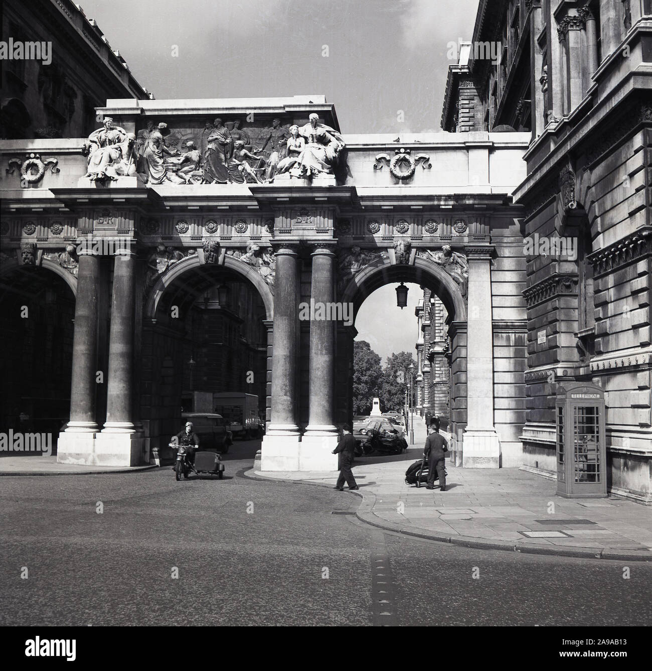 1950, historische, Motorrad mit Beiwagen unterhalb der mittleren Bogen am Triple Arch am King Charles Street, Whitehall, London, England, UK. Die Brücke verbindet es öffentlichen Gebäuden. Stockfoto