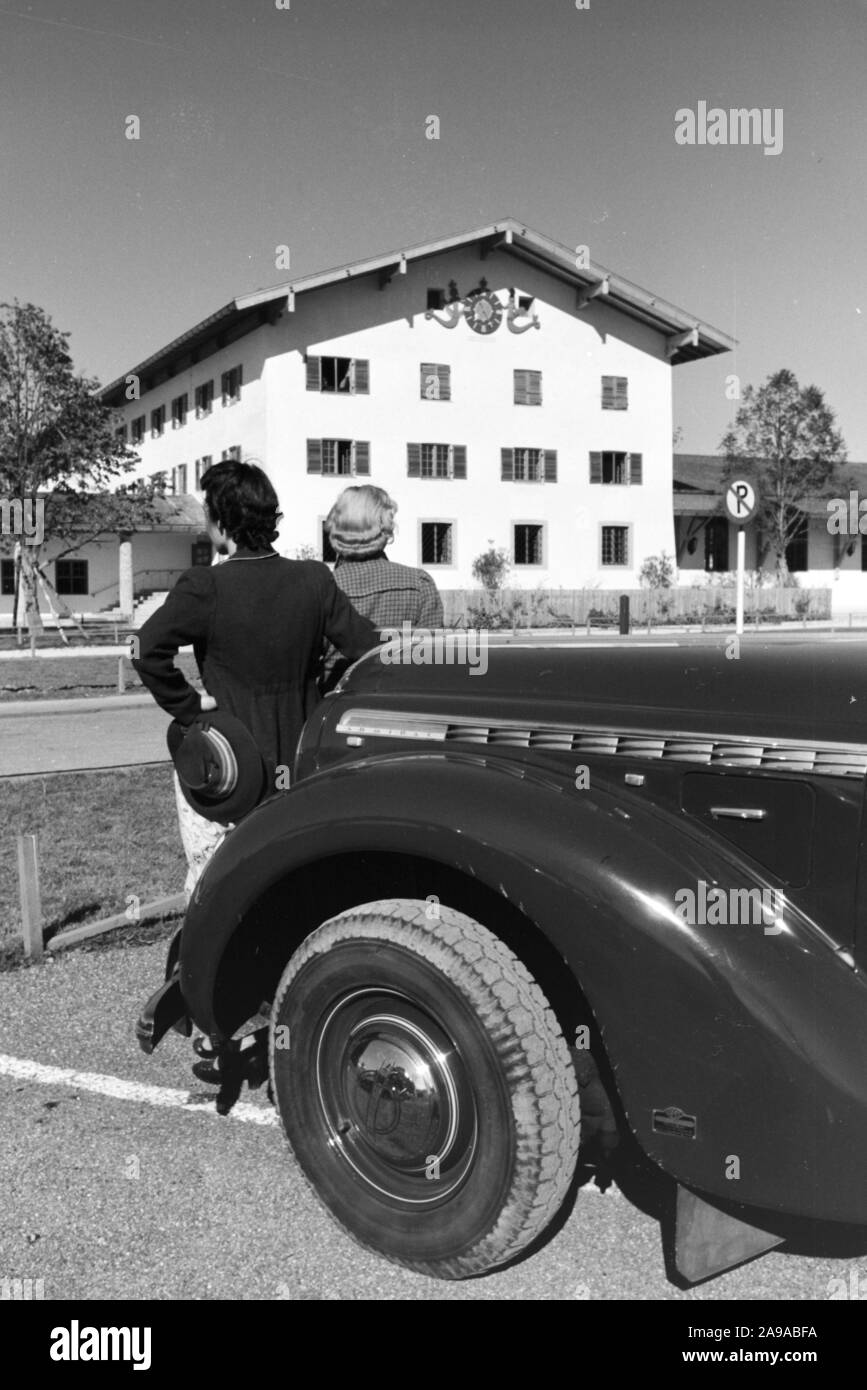 Zwei junge Frauen sind ein Blick auf die Uhr an der Wand der Stadt Halle auf dem Chiemsee, Deutschland 1930. Stockfoto