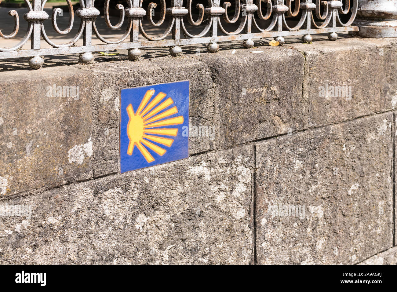 Camino de Santiago schild Kachel auf der Steinmauer. Jakobsweg weg Shell. Stadt Santiago de Compostela, Spanien Stockfoto