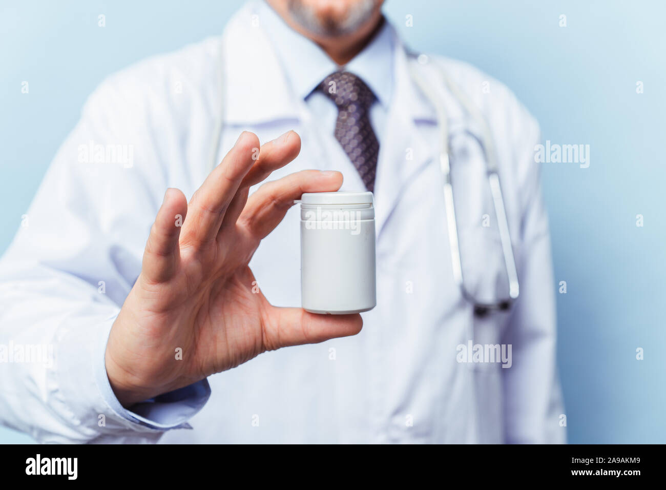 Arzt holding Flasche Pillen auf weißem Hintergrund. Das Konzept von Medizin, Pharmakologie, Gesundheitswesen Stockfoto