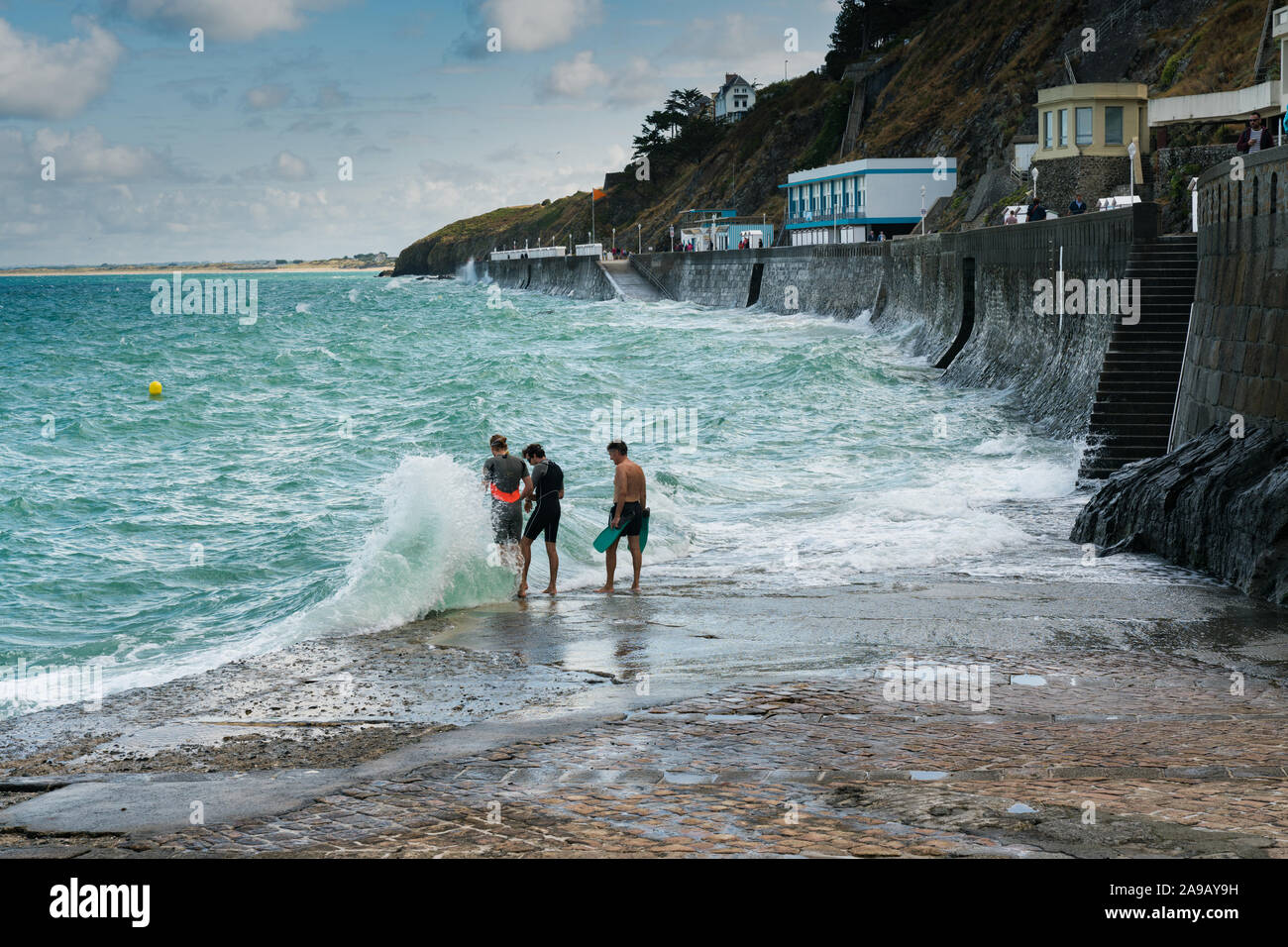 Granville, Manche/Frankreich - 18. August 2019: drei freie Taucher Vorbereitung in stürmischen Ozean zu springen Stockfoto