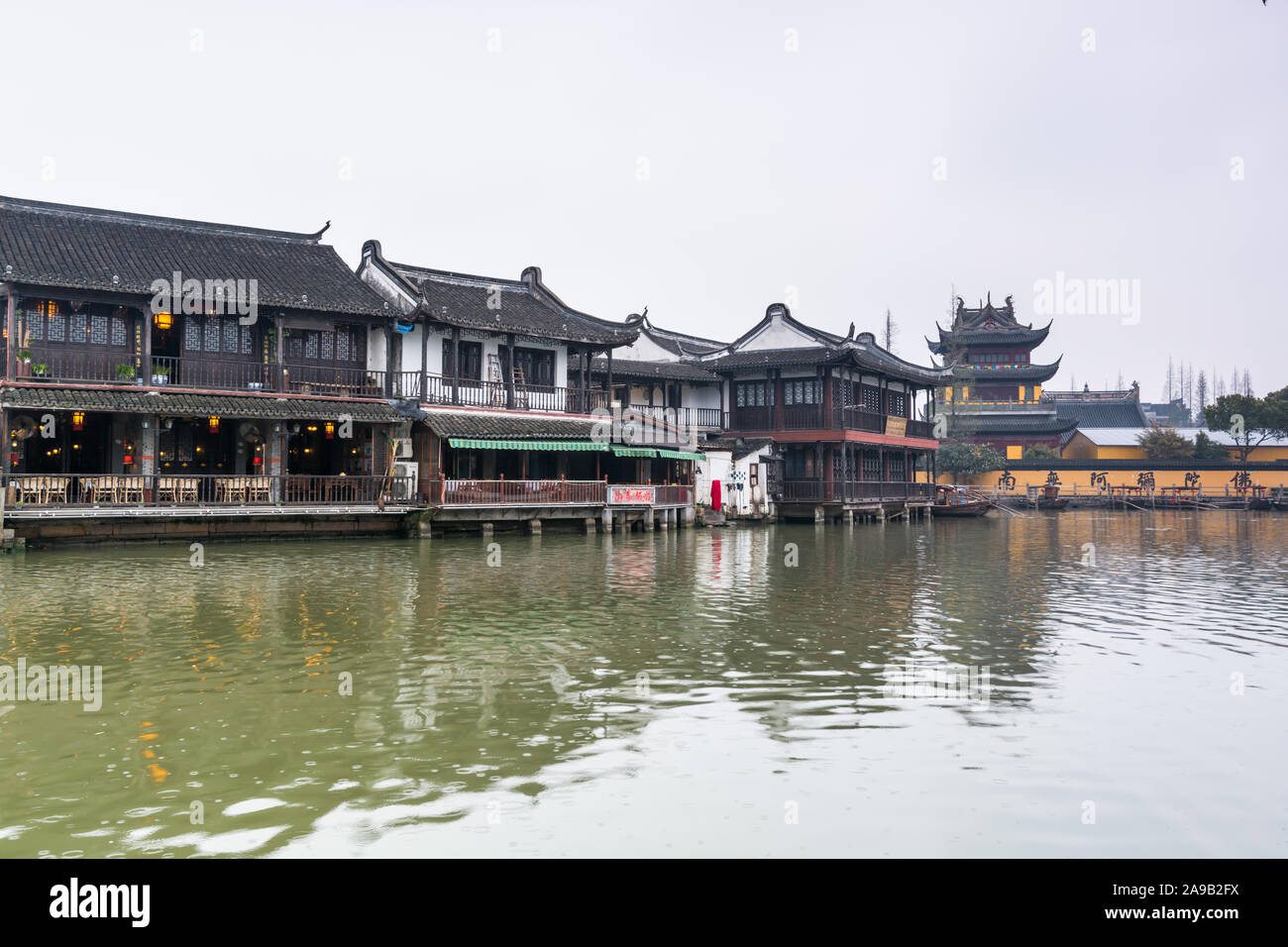 Blick auf die Straße mit historischen Gebäuden und buddhistischen Tempel in Zhujiajiao in einer regnerischen Tag, eine alte Wasser Stadt in Shanghai, während der Ming-dynastie erbaut und Stockfoto