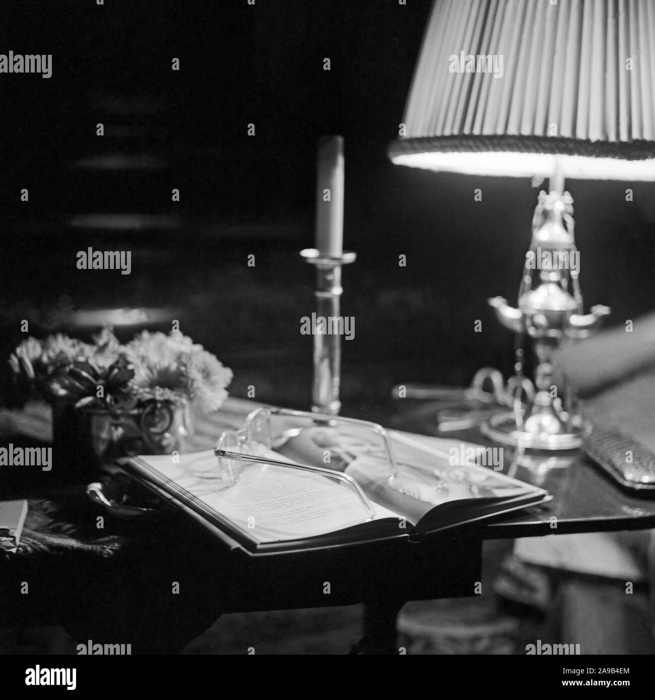 Gläser auf eine geöffnete Buch auf einem Beistelltisch, Deutschland 1956 Stockfoto