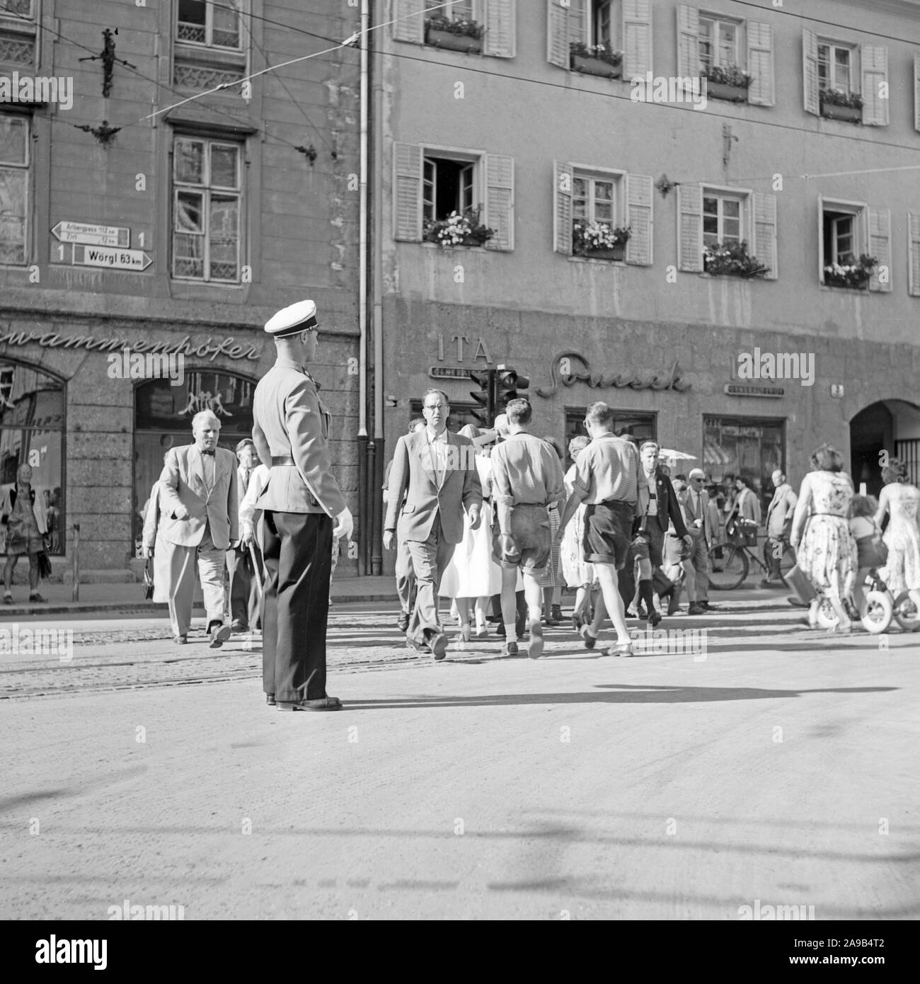 Überqueren der Straße vor Schwammenhoefer's Kürschner Handel in Innsbruck, Österreich 1958 Stockfoto