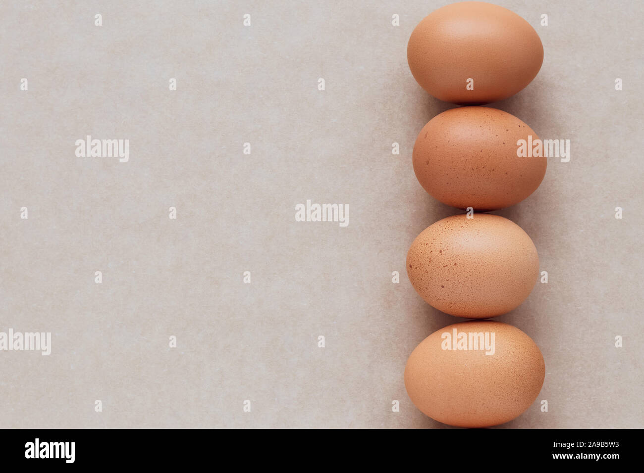 Die braune Eier auf neutralem Papier Hintergrund. Eine Gruppe von Hühnereiern auf beige Tabelle. Karte Rahmen mit dem Text. Stockfoto