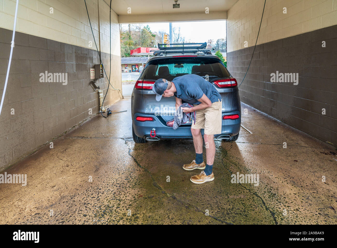 Von Autoteilen - Mann trocknet Fenster auf der Rückseite des Fahrzeugs, in dem Auto waschen. Stockfoto