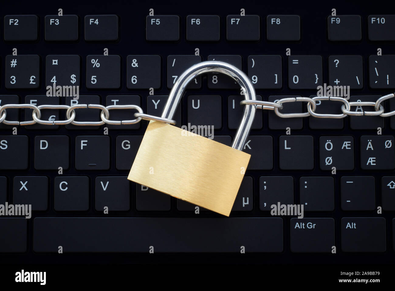 Computer Tastatur durch ein Metall Kette und Schloss gesichert. Konzept Foto von Cyberkriminalität und Internet und Computer Sicherheit und Sicherheit. Stockfoto