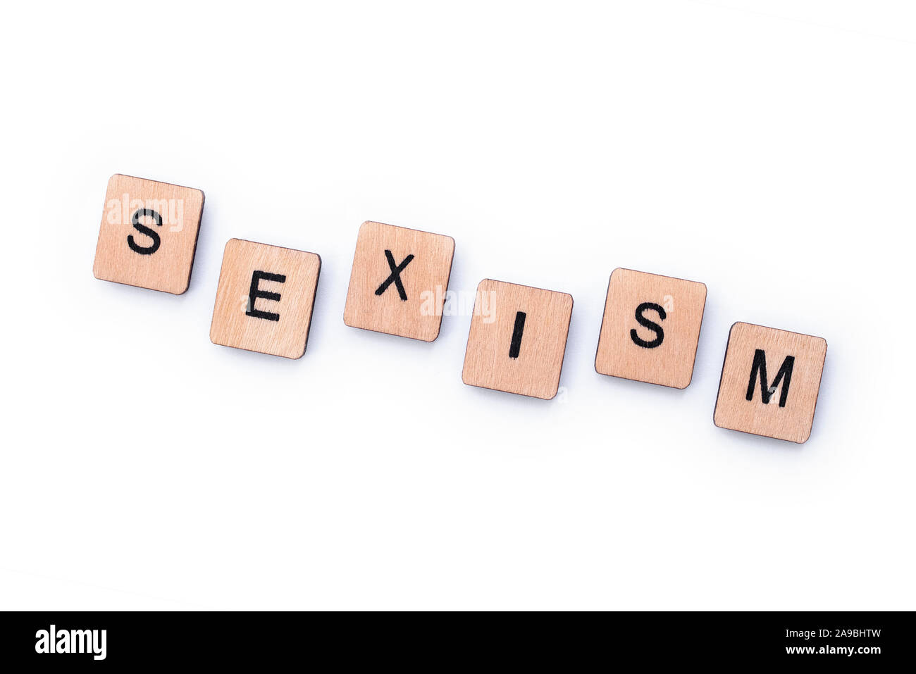 Das Wort Sexismus, Dinkel mit hölzernen Buchstabensteine über einem weißen Hintergrund. Stockfoto