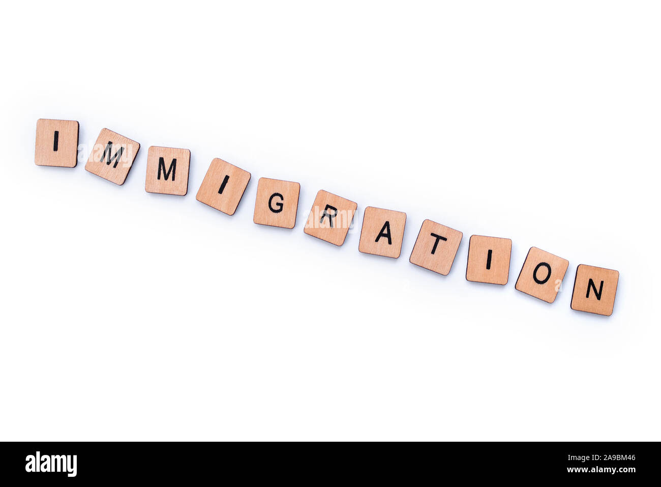 Das Wort "Einwanderung", Dinkel mit hölzernen Buchstabensteine über einem weißen Hintergrund. Stockfoto
