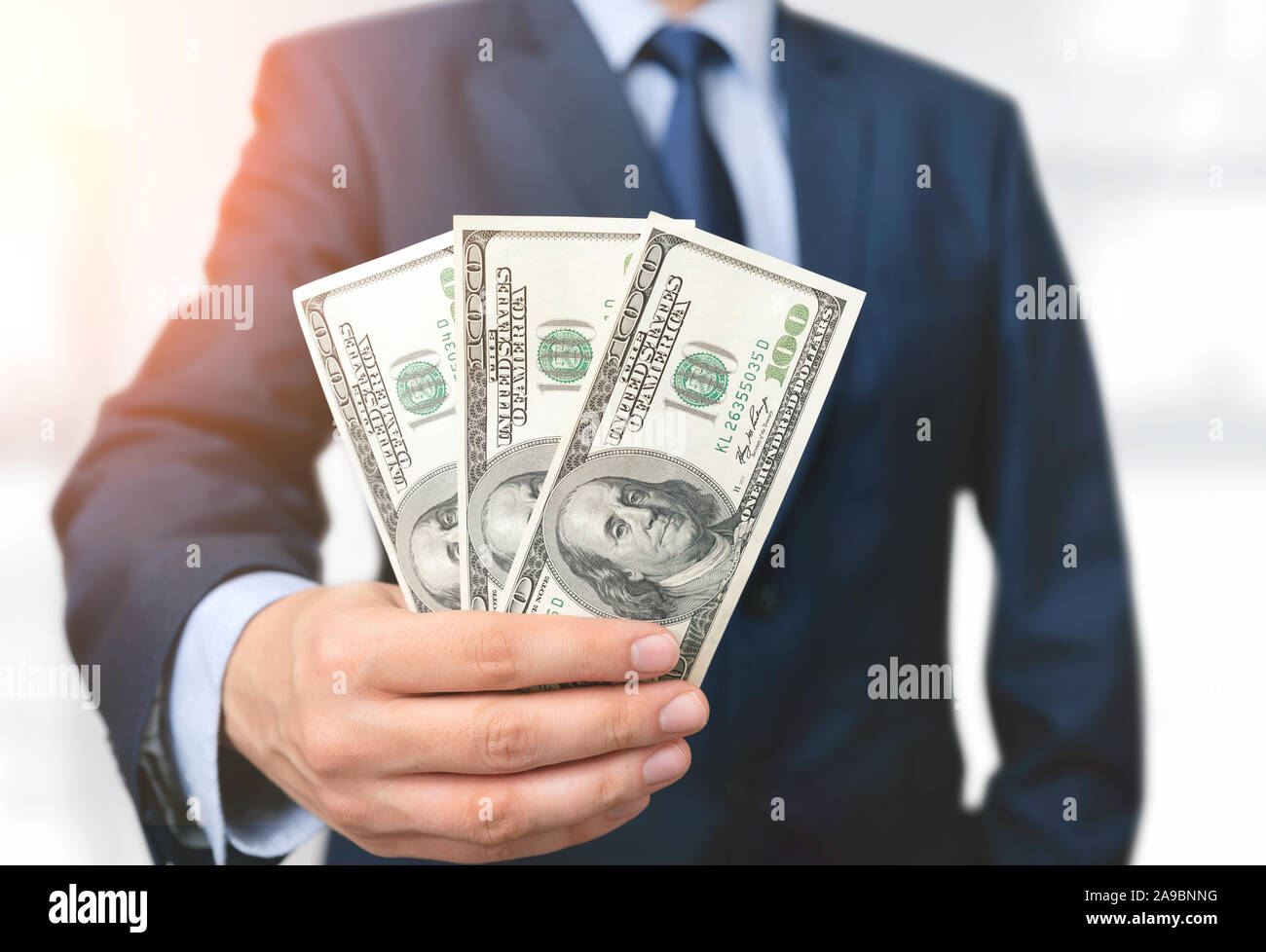 Mann im Anzug hält hundert Dollar Banknoten. Geschäfts-, Finanz- und Gehalt Konzept Stockfoto