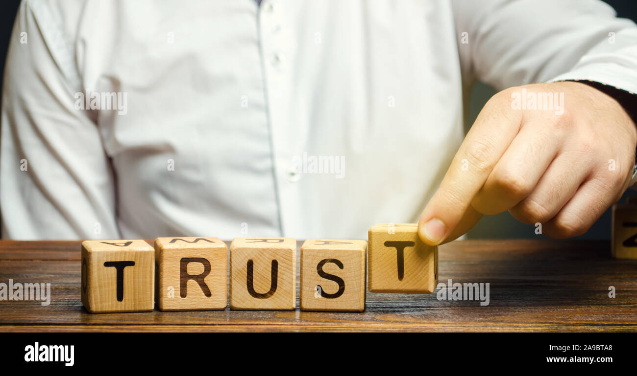 Holzblöcke mit dem Wort vertrauen. Vertrauensstellungen zwischen Geschäftspartnern, Freunden, Verwandten. Respekt und Autorität. Das Vertrauen in eine Person. R Stockfoto