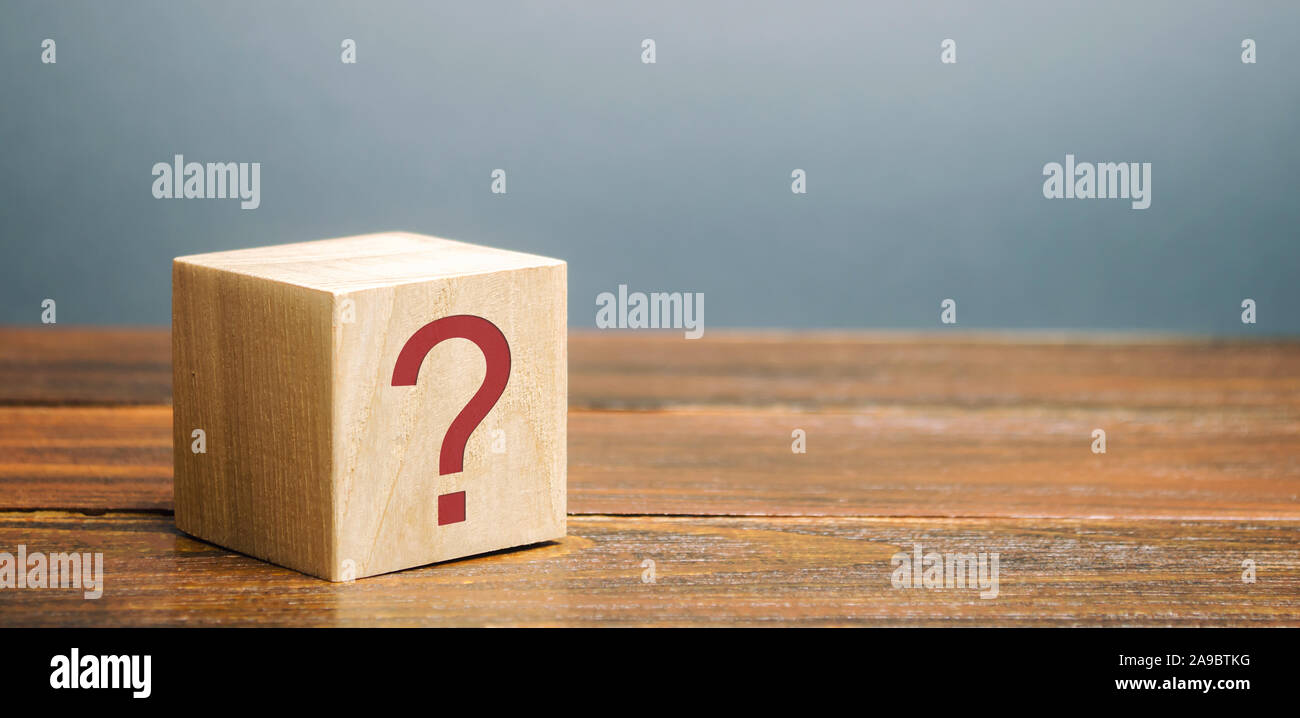 Holzblock mit einem Fragezeichen. Fragen, auf die Suche nach der Wahrheit. Rätsel, Geheimnis, Untersuchung und Forschung. FAQ - Häufig gestellte Fragen Stockfoto