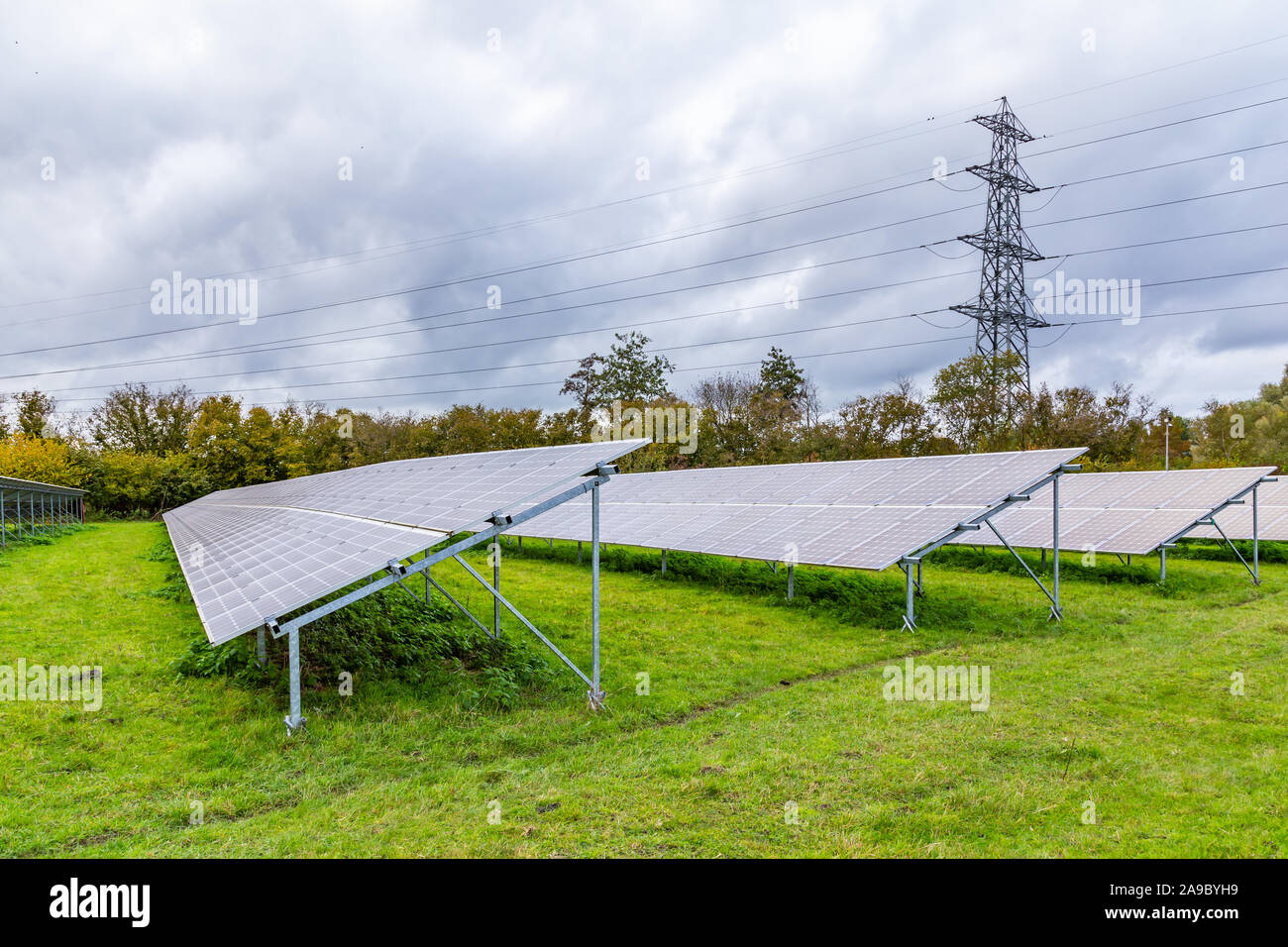 Moderne Sonnenkollektoren und hohe Spannung post in einer holländischen Landschaft Stockfoto