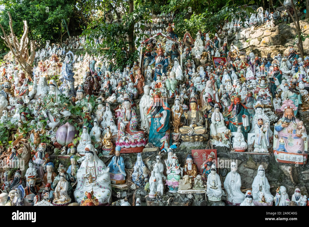 Hunderte von kleinen Statuen, die Götter der verschiedenen Religionen an einem Hügel in einem Coastal Park im Waterfall Bay, Hong Kong sitzen. Stockfoto