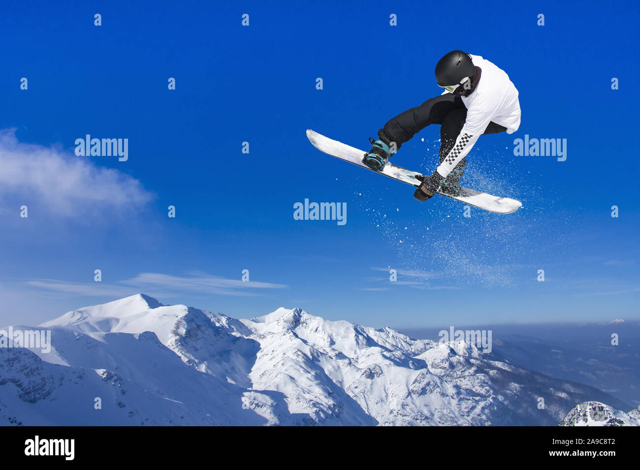 Skifahrer, Snowboarder, springen durch die Luft mit blauen Himmel im Hintergrund Stockfoto