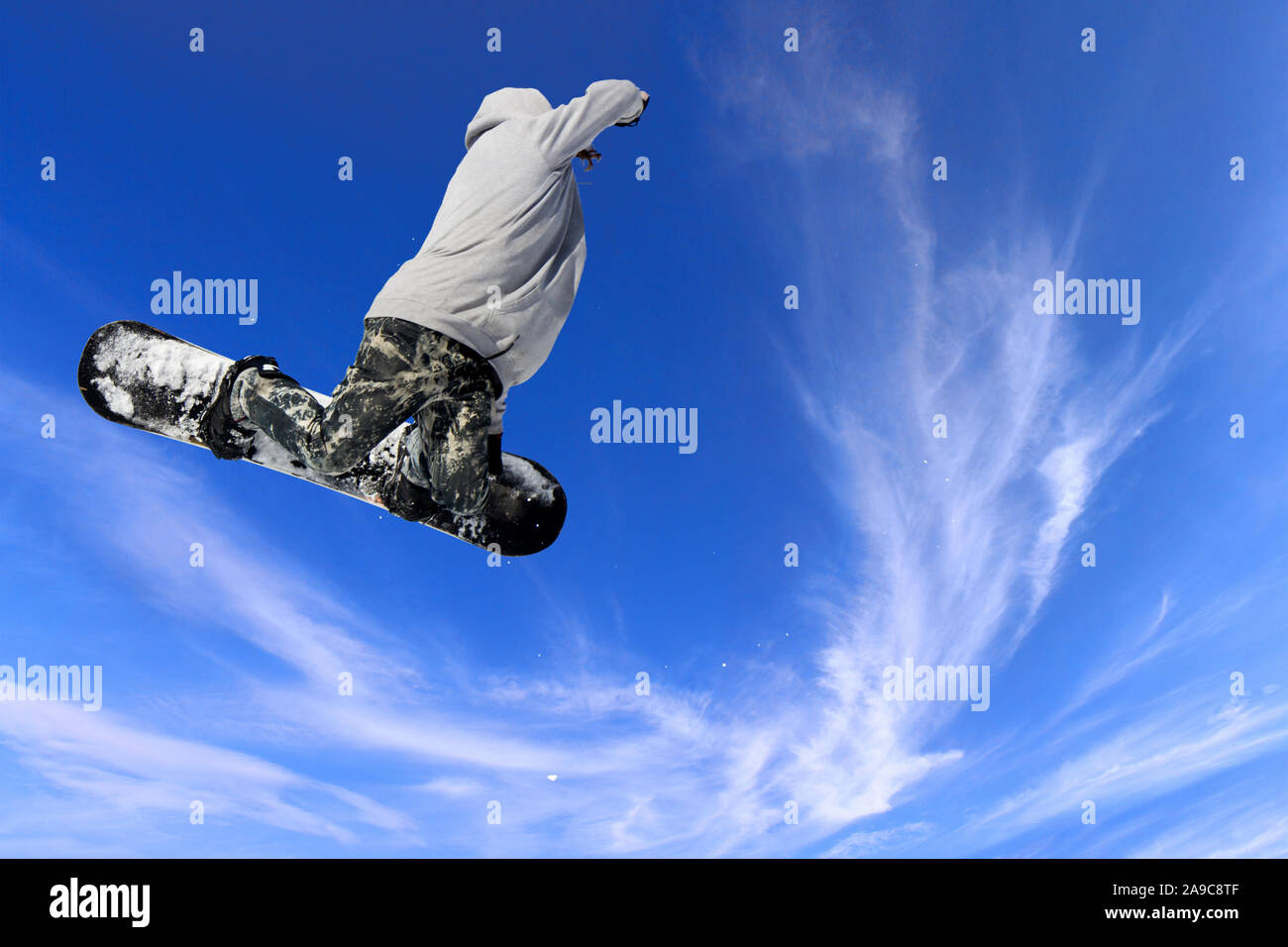 Skifahrer, Snowboarder, springen durch die Luft mit blauen Himmel im Hintergrund Stockfoto