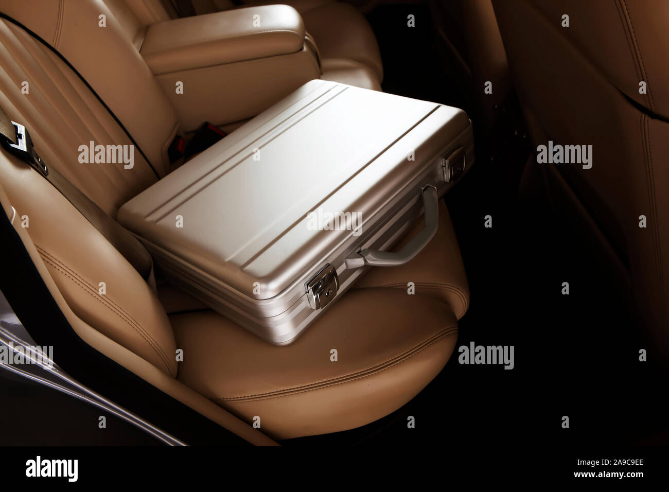 Luxus Metall Aktenkoffer auf eine erlesene Auto Rücksitz. Creme Leder Stockfoto