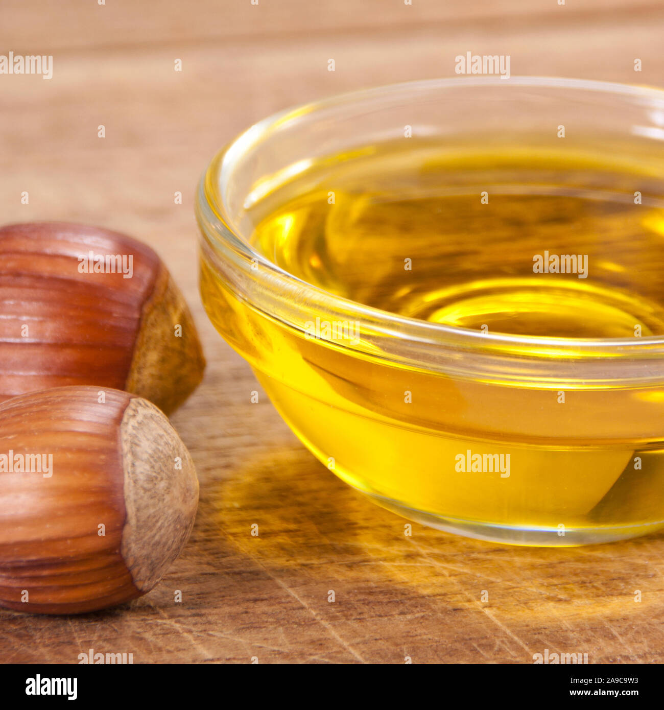 Haselnussöl gegen Holz- Hintergrund Stockfoto