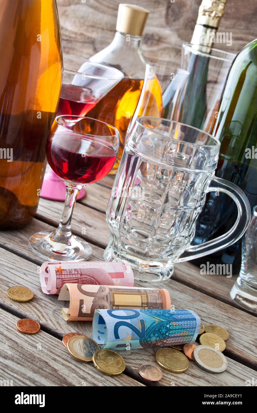 Alkohol Getränke und Euro auf hölzernen Tisch Stockfoto
