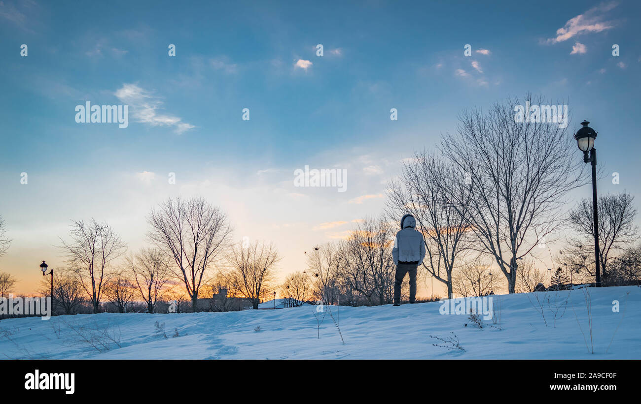 Winterlandschaft mit einer Person. Blauer Himmel bei Sonnenuntergang mit Schnee Stockfoto